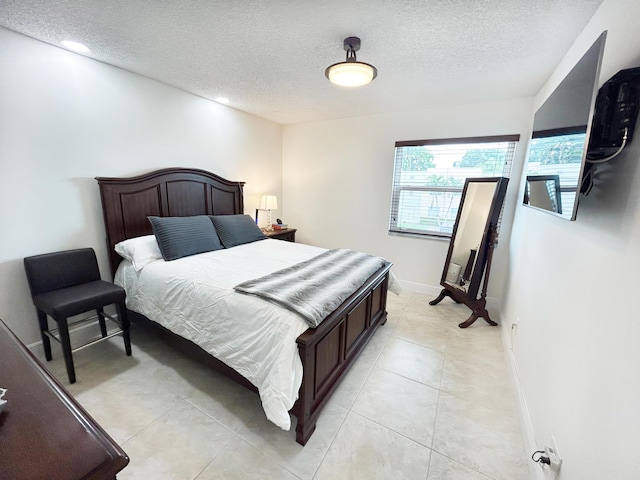 bedroom featuring a textured ceiling and light tile patterned floors