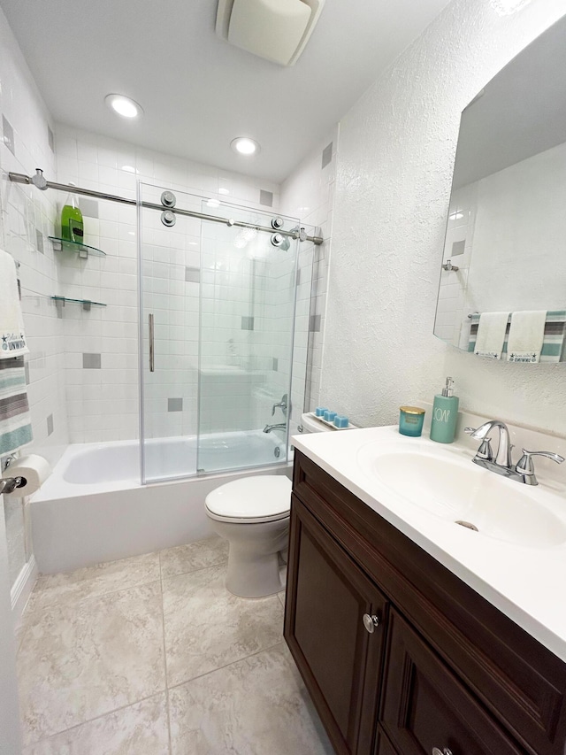 full bathroom featuring vanity, combined bath / shower with glass door, and toilet