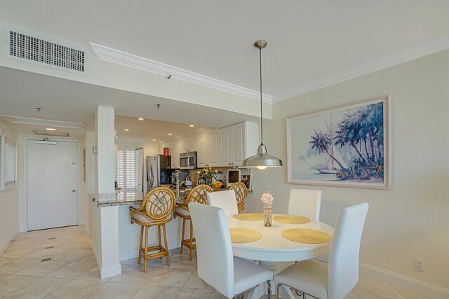 dining room featuring crown molding and light tile patterned floors