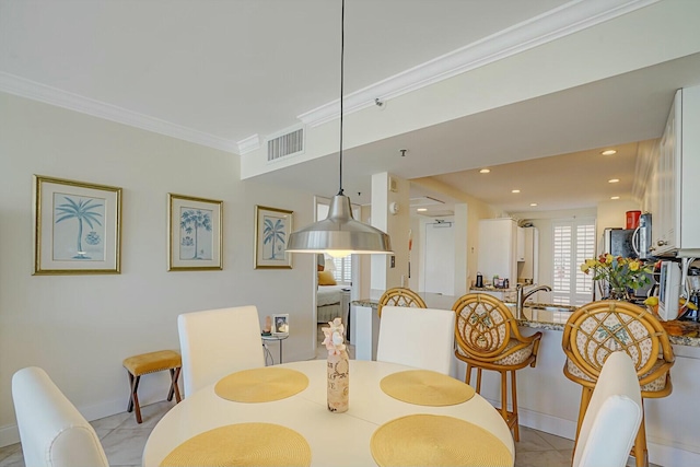 dining room featuring crown molding and light tile patterned floors