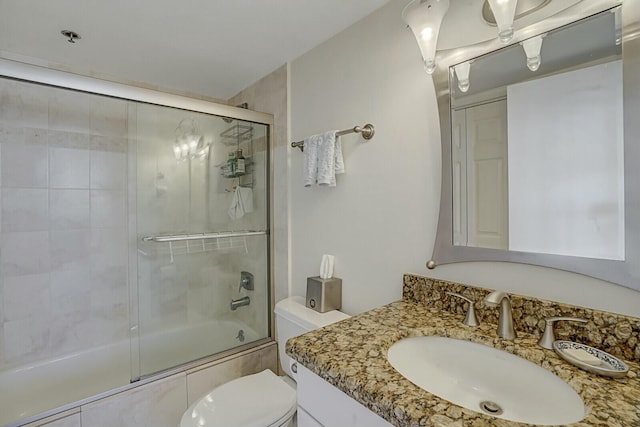 full bathroom with vanity, enclosed tub / shower combo, and toilet