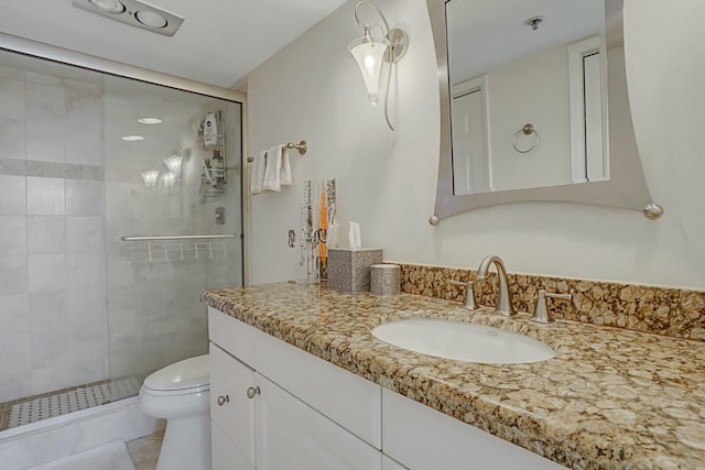 bathroom with walk in shower, vanity, and toilet