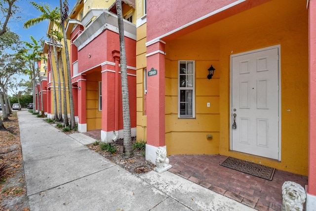 doorway to property featuring stucco siding