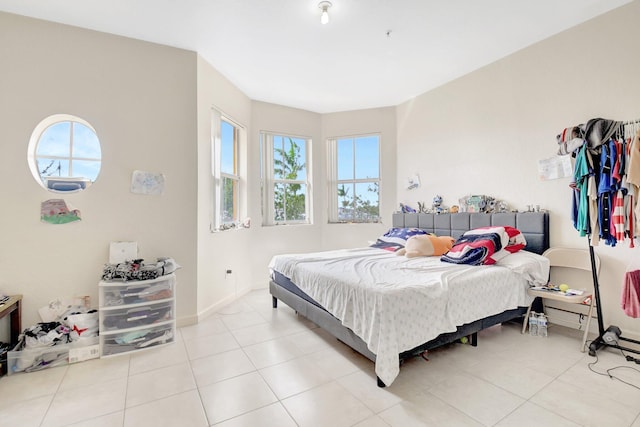 bedroom featuring light tile patterned floors and baseboards