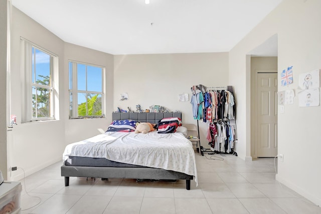 bedroom with light tile patterned floors and baseboards