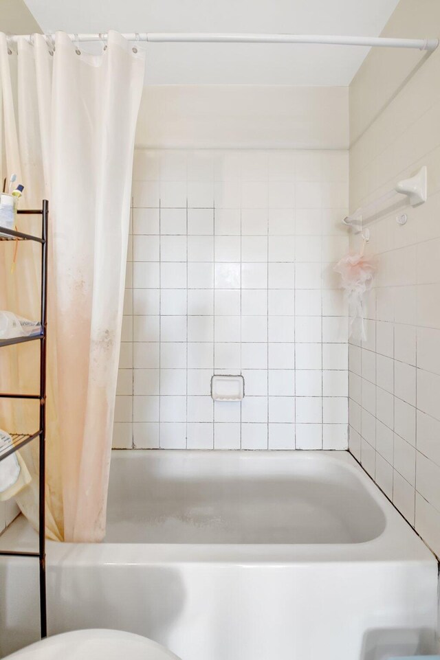 full bathroom with shower / bath combination with curtain and toilet