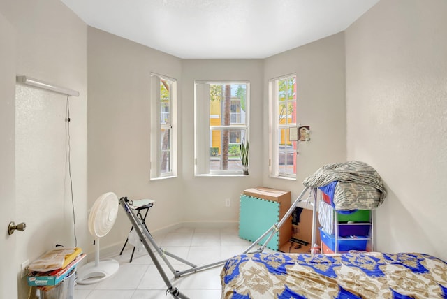 bedroom with light tile patterned flooring and baseboards