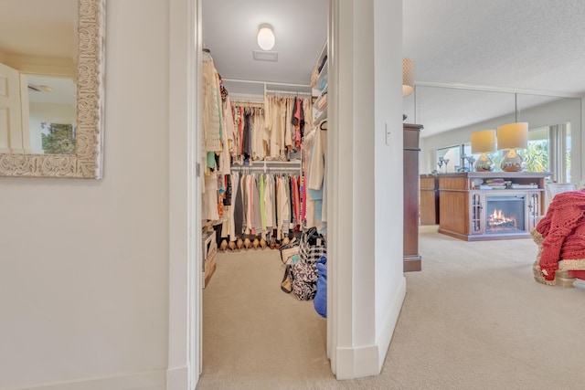 walk in closet featuring light colored carpet