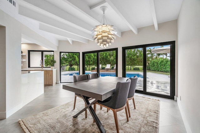 dining space with beamed ceiling, a chandelier, and sink