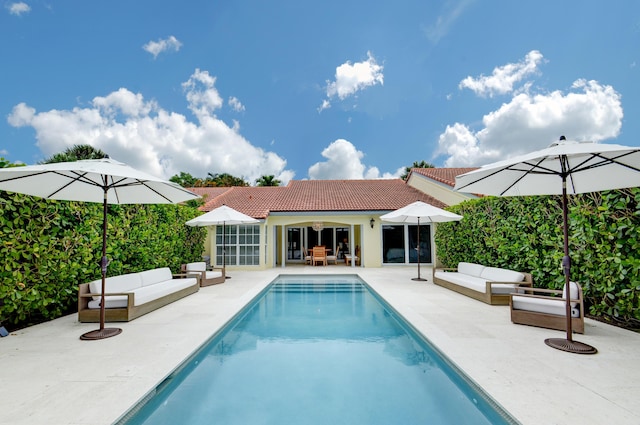 outdoor pool with a patio area and an outdoor living space