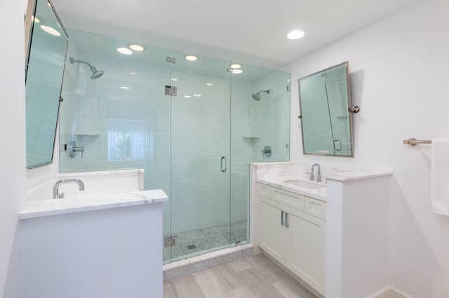 bathroom with recessed lighting, vanity, and a shower stall