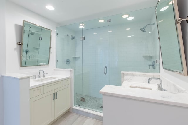 bathroom with wood finished floors, a shower stall, vanity, and recessed lighting