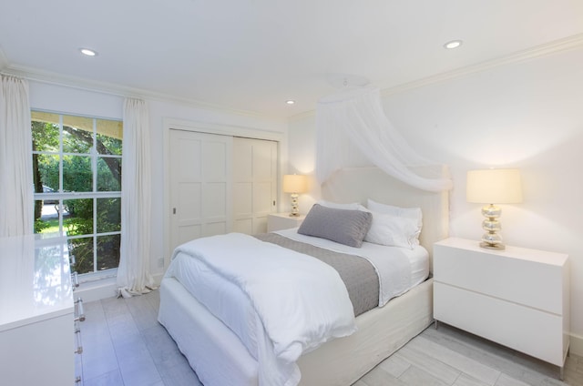 bedroom with ornamental molding, recessed lighting, a closet, and light wood-style floors