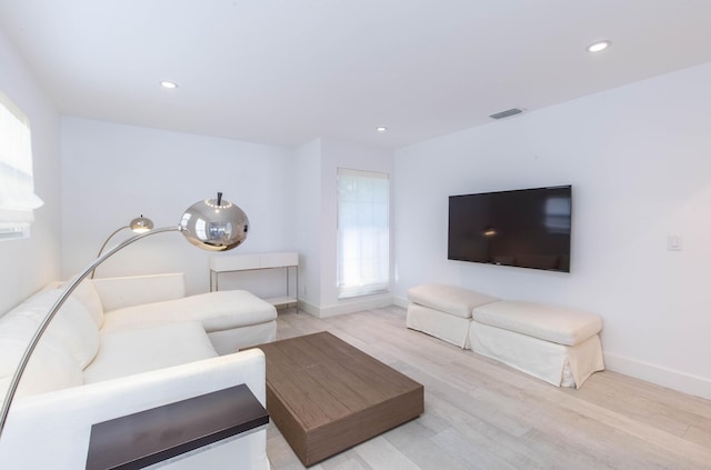 living area with visible vents, baseboards, light wood-style flooring, and recessed lighting