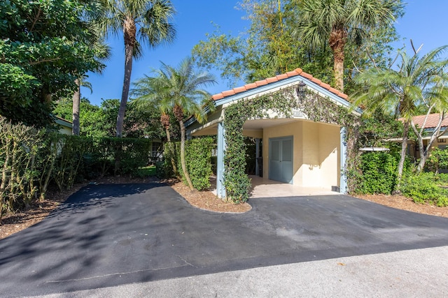 exterior space featuring aphalt driveway and an attached carport