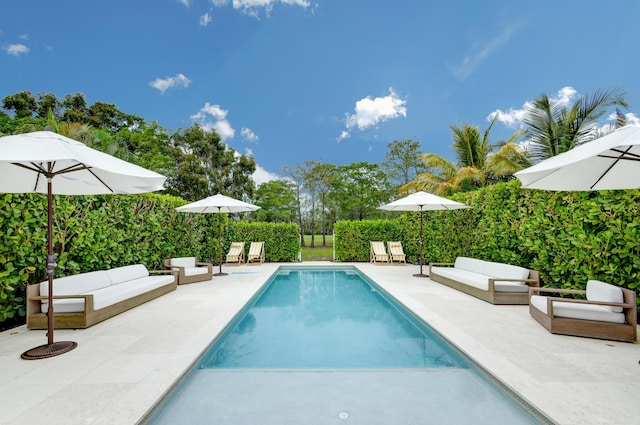 view of swimming pool featuring outdoor lounge area, a fenced in pool, and a patio