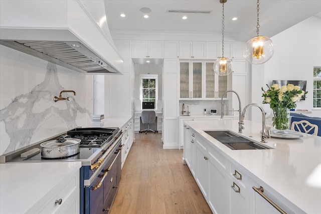 kitchen with decorative light fixtures, custom range hood, and white cabinets