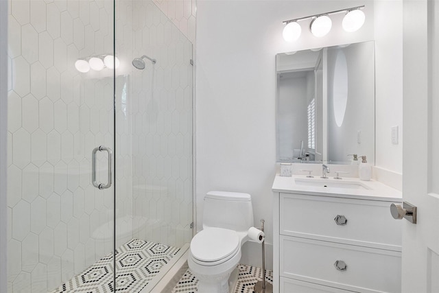 bathroom featuring vanity, a shower with shower door, and toilet