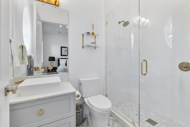 bathroom with vanity, toilet, and a shower with door