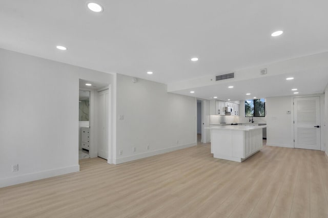 kitchen featuring white cabinetry, light wood-type flooring, and a kitchen island