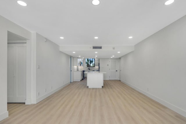 kitchen featuring light wood-type flooring, white cabinets, and a kitchen island