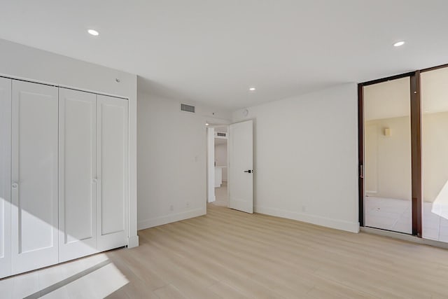 unfurnished bedroom with a closet and light hardwood / wood-style flooring