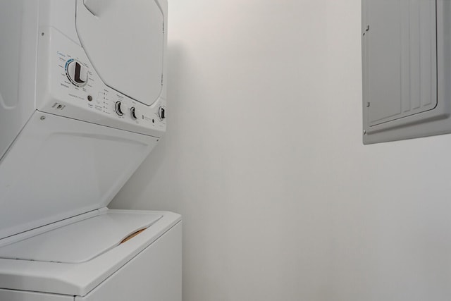 washroom with stacked washing maching and dryer and electric panel