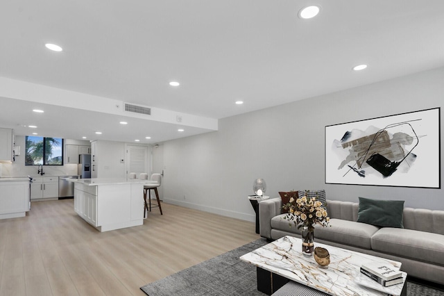 living room with sink and light hardwood / wood-style flooring