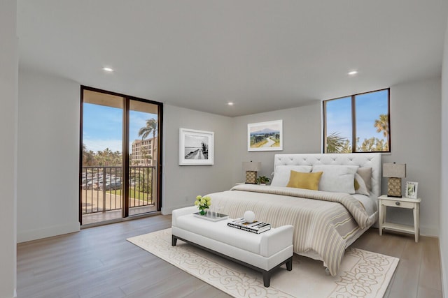 bedroom with floor to ceiling windows, light hardwood / wood-style floors, and access to outside