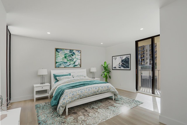 bedroom featuring expansive windows and light hardwood / wood-style floors