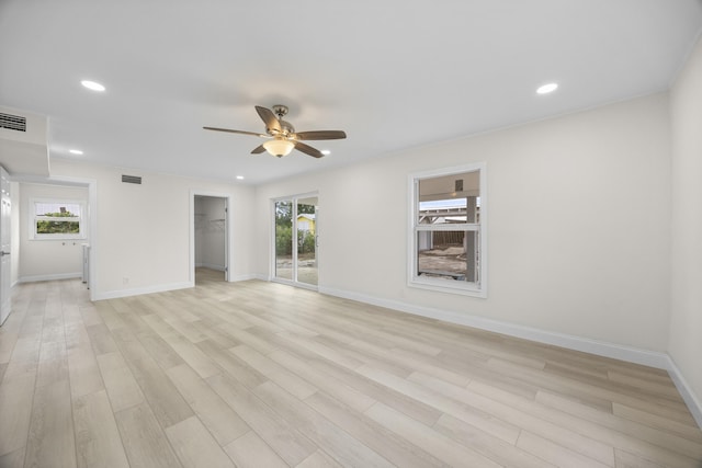 spare room featuring light hardwood / wood-style flooring, a wealth of natural light, and ceiling fan