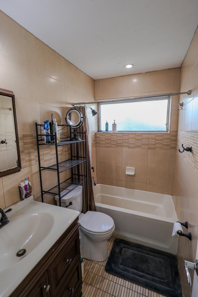 full bathroom with shower / tub combo, tile patterned flooring, tile walls, vanity, and toilet