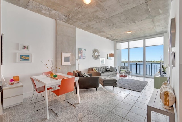 interior space featuring light tile patterned flooring, expansive windows, and a water view