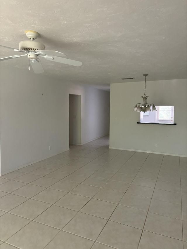 unfurnished room with light tile patterned floors, ceiling fan, and a textured ceiling