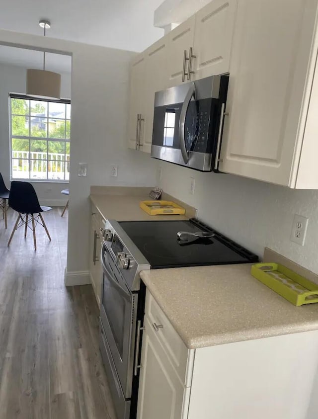 kitchen with white cabinetry, stainless steel appliances, and light hardwood / wood-style floors