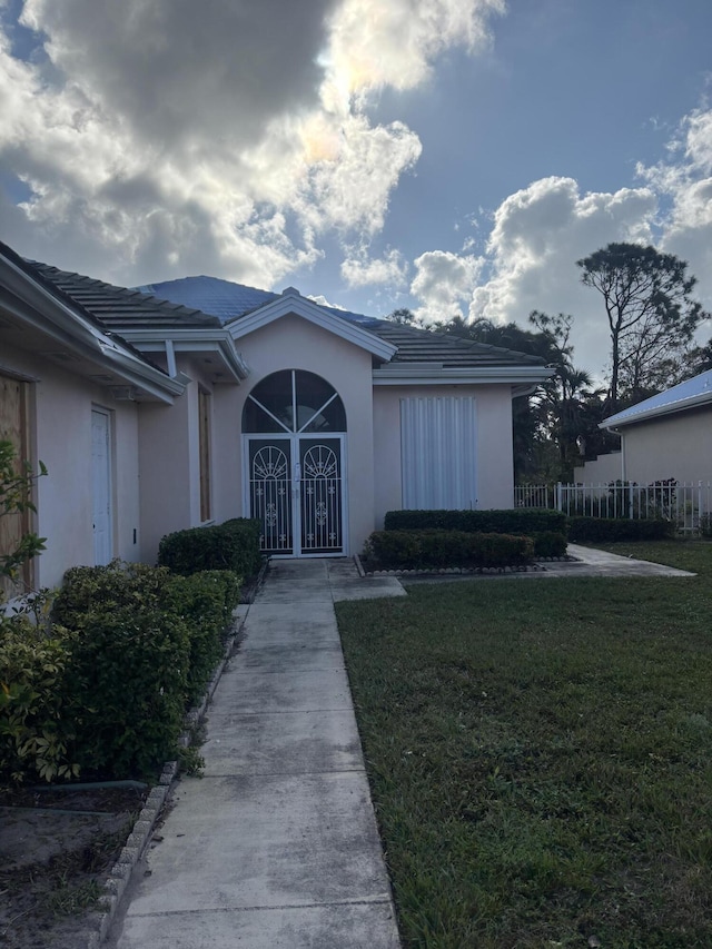 view of exterior entry featuring a yard