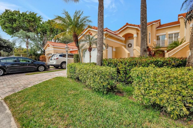 view of front of house with a tile roof, an attached garage, and stucco siding