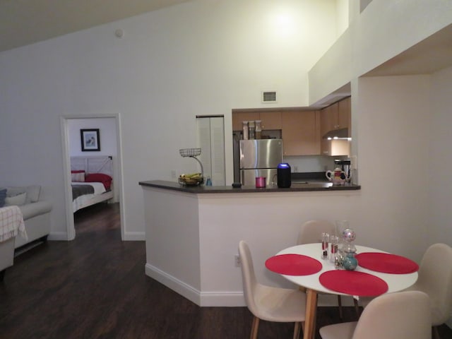 dining room featuring high vaulted ceiling, visible vents, baseboards, and dark wood-style floors