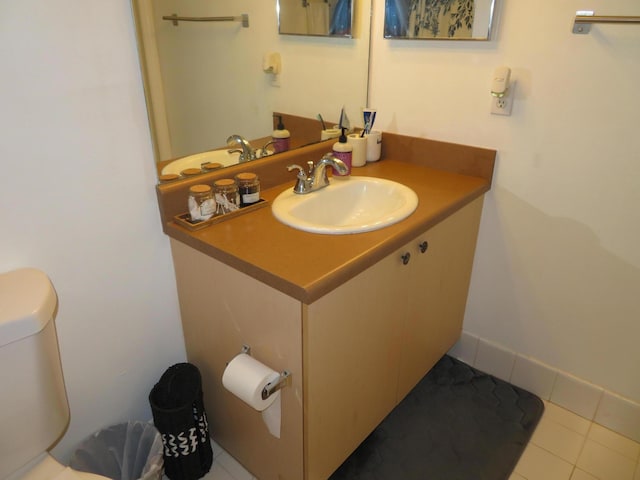 bathroom with toilet, tile patterned flooring, and vanity