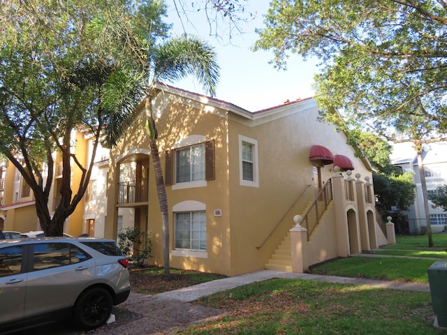 view of side of home featuring stairs and stucco siding