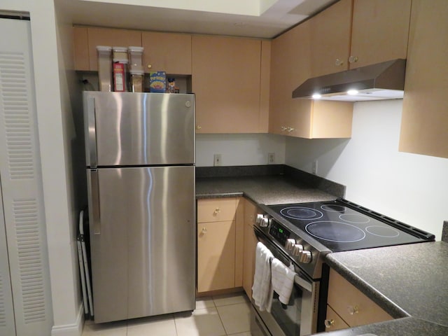 kitchen with stainless steel appliances, dark countertops, light brown cabinetry, light tile patterned flooring, and exhaust hood