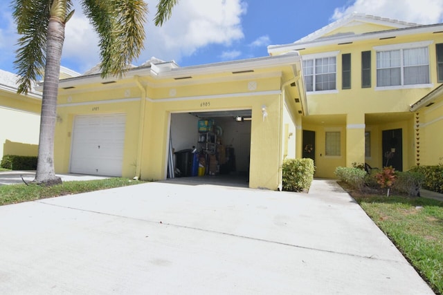 view of front of property featuring a garage, driveway, and stucco siding