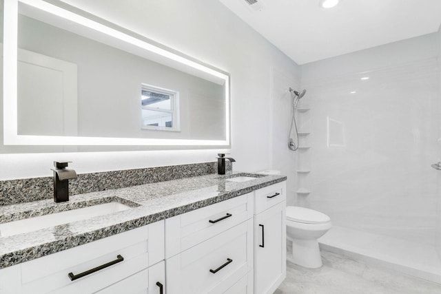 bathroom with vanity, a shower, and toilet