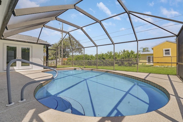 view of swimming pool with a patio, a lawn, glass enclosure, and french doors