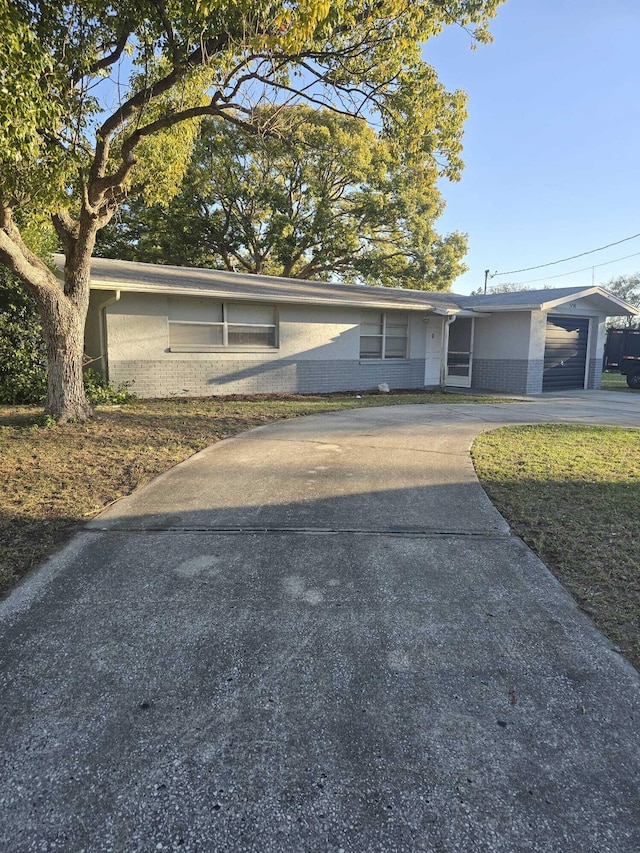 ranch-style home featuring brick siding and driveway