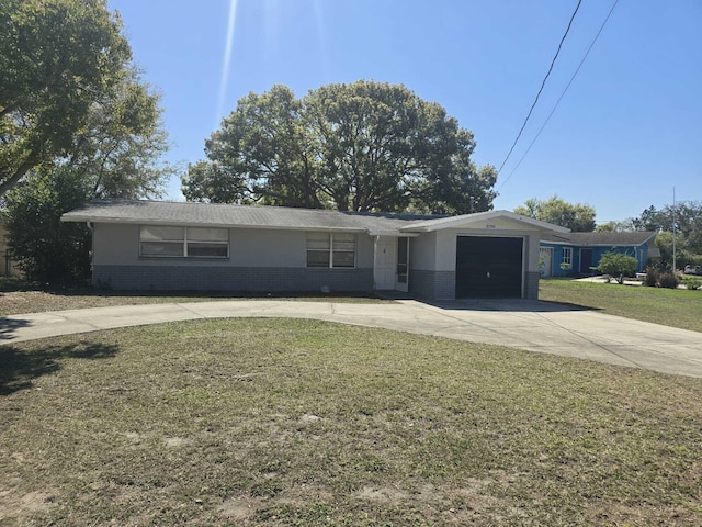 single story home featuring concrete driveway, an attached garage, brick siding, and a front lawn