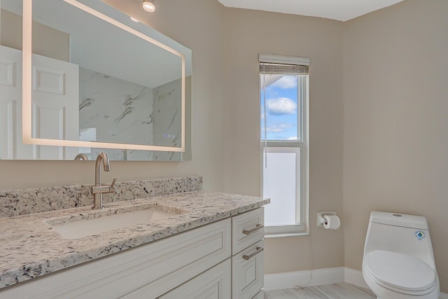 bathroom featuring vanity, a wealth of natural light, and toilet