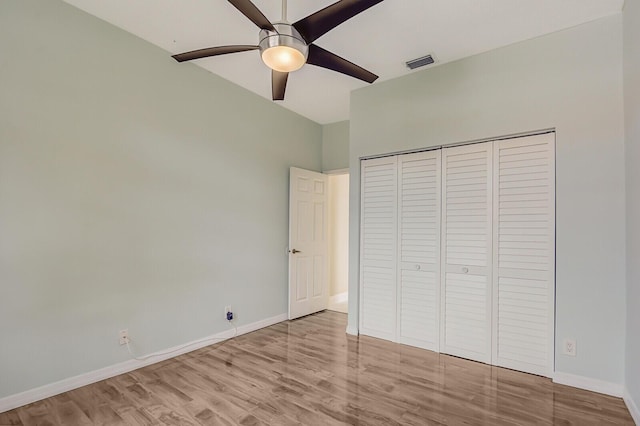 unfurnished bedroom featuring ceiling fan, light hardwood / wood-style floors, and a closet