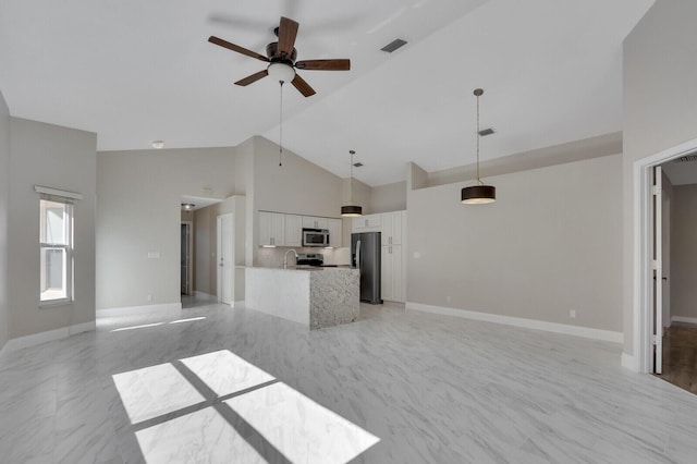 unfurnished living room featuring ceiling fan, sink, and high vaulted ceiling