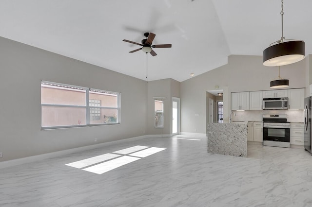 kitchen with sink, high vaulted ceiling, hanging light fixtures, stainless steel appliances, and white cabinets